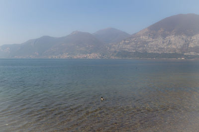 Scenic view of sea and mountains against sky