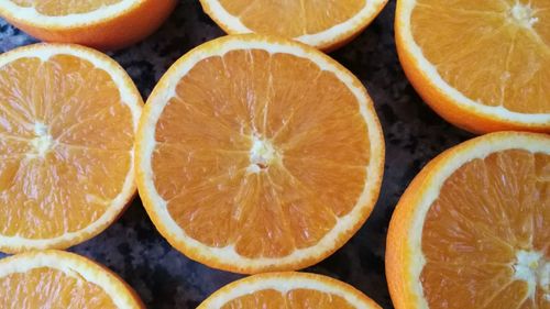 Full frame shot of halved oranges arranged on table