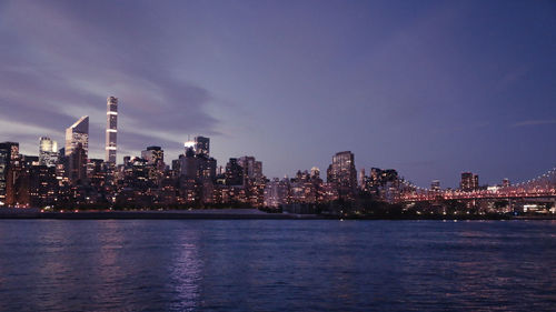 Illuminated buildings in city against sky at night