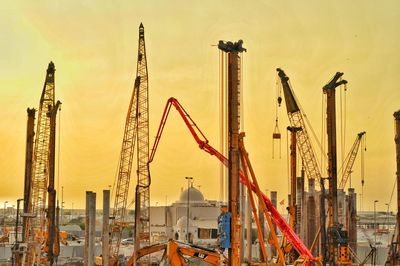 Cranes at construction site during sunset