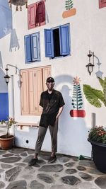 Full length of man in mask standing against wall outdoors