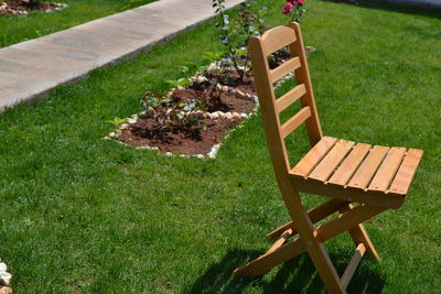 Empty bench on grassy field