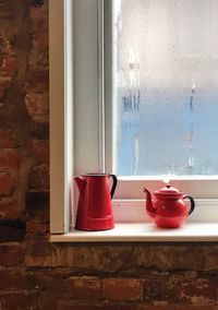 Close-up of teapot on window sill at home