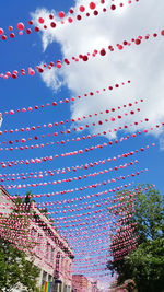 Low angle view of multi colored flags hanging against sky