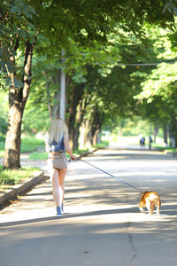 Rear view of woman walking on road