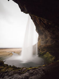 Scenic view of waterfall against sky