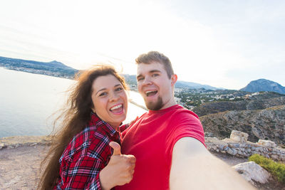 Portrait of smiling young couple against mountain