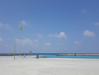 View of calm beach against blue sky