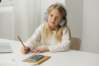 Young woman using digital tablet at table