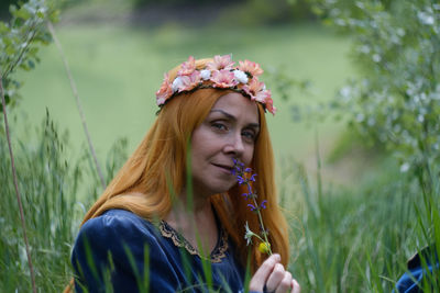 Portrait of beautiful young woman with flower petals on field