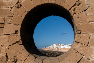 Buildings seen through hole in wall