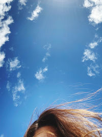 Low angle view of woman against blue sky