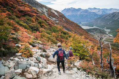 Rear view of men walking on mountain road