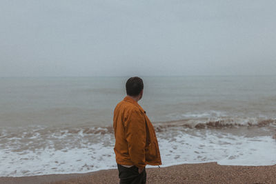 Rear view of man standing at beach