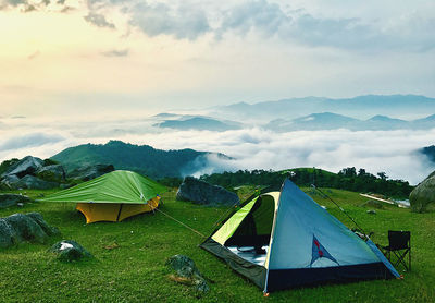 Tent on field by mountain against sky