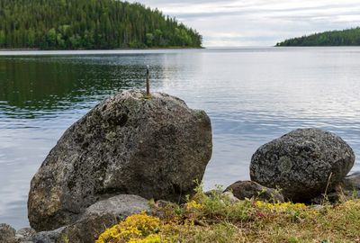 Scenic view of rocks by lake against sky