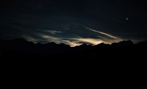 Low angle view of silhouette mountain against sky at night