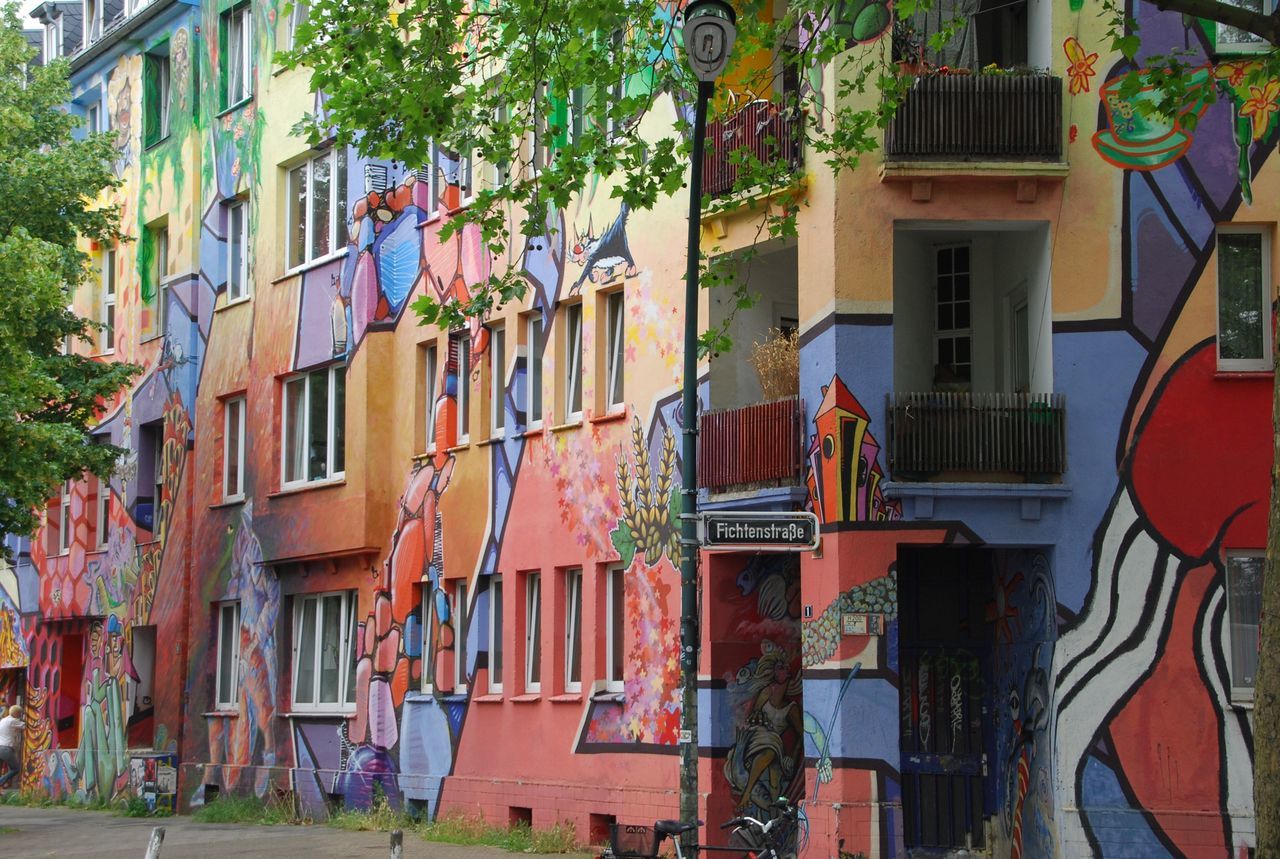 building exterior, architecture, built structure, residential building, residential structure, house, window, tree, building, multi colored, city, low angle view, day, outdoors, no people, balcony, street, facade, sunlight, residential district