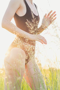 Slim woman in swimsuit in field grass scenic photography