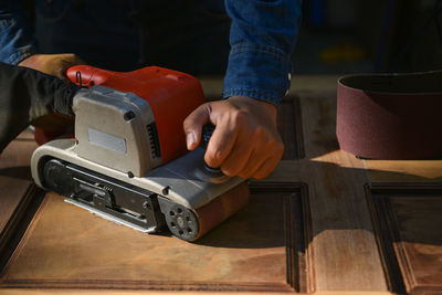 Close-up of man using smart phone on table