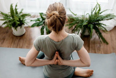 Beautiful young woman doing exercises and doing yoga at home