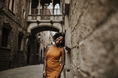 Smiling woman leaning on wall, barcelona, spain