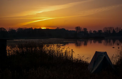 Scenic view of lake against orange sky