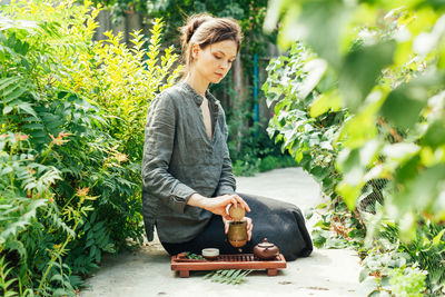 Full length of woman standing against plants