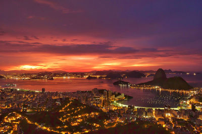 High angle view of illuminated residential district and guanabara bay at dusk