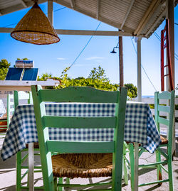 Empty chairs and tables at restaurant against sky
