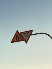 Low angle view of road sign against clear sky