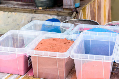 High angle view of powder paint in containers on table
