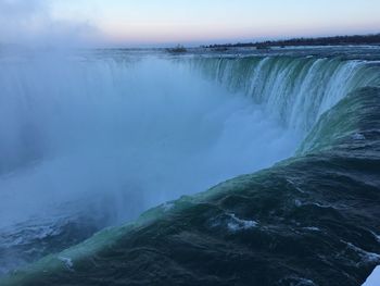 Scenic view of waterfall against sky