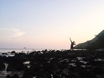 Silhouette of people on beach against sky