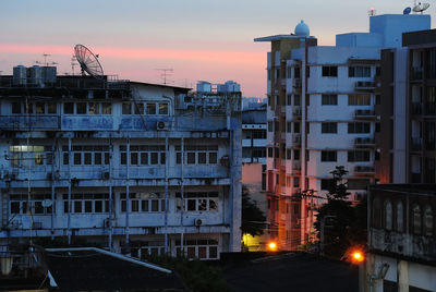 Apartment buildings in town against sky at dusk