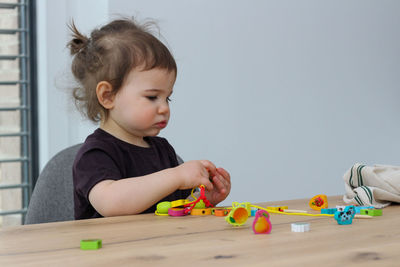 Cute boy with toy on table