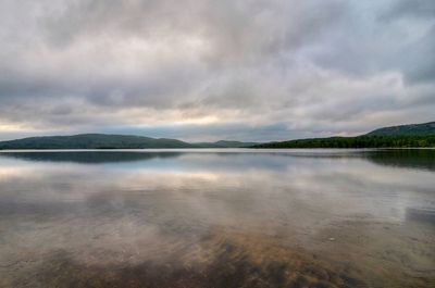 Scenic view of lake against cloudy sky