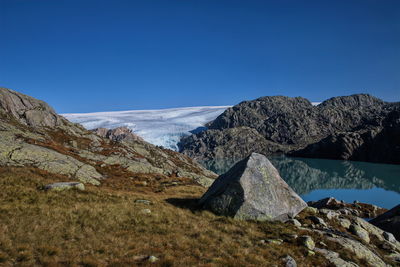 Scenic view of snowcapped mountains against clear blue sky