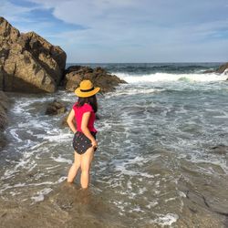 Full length of boy standing on beach against sky