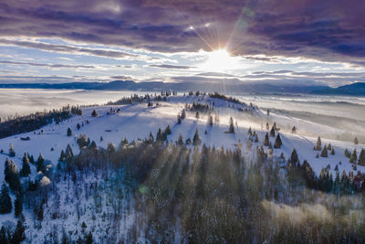 Scenic view of snowcapped mountains against sky during sunset