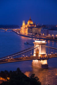 Illuminated bridge over river at night