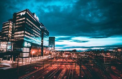 Illuminated buildings in city against sky at night