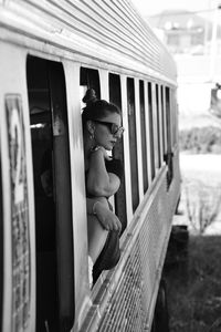 Young woman peeking out from train window