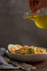 Pouring olive oil on beans salad. healthy nutrition concept