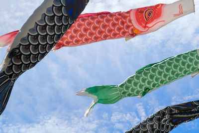 Low angle view of colorful kites flying in sky