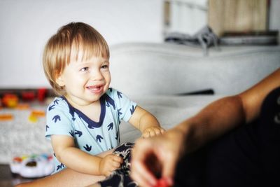 Smiling boy with mother sitting at home