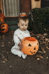 Boy with pumpkin on wood during halloween