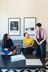 Male and female business colleagues planning strategy while sitting on sofa in office