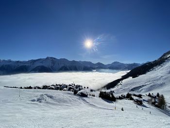 Scenic view of snow covered mountains against bright sky