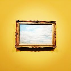 Yellow mirror against sky